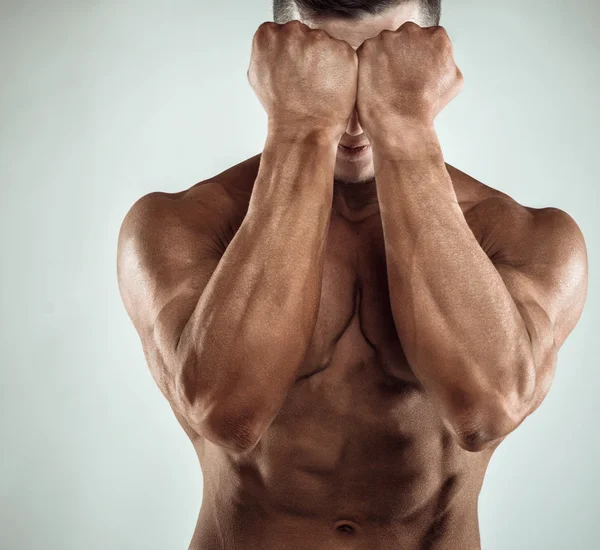 Duas mãos de Power Mans na frente da cara. Close-up de punhos e abdominais de um homem . — Fotografia de Stock