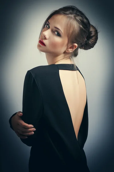 Retrato de una hermosa mujer morena en vestido negro. Sombras cosméticas. Foto de moda — Foto de Stock