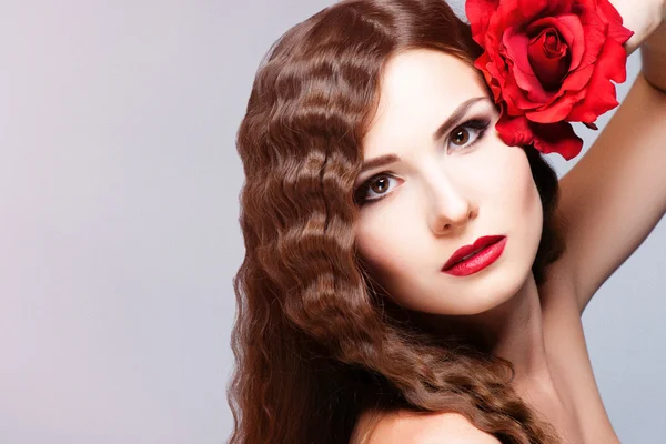 Hermosa joven modelo con labios rojos y rosa roja — Foto de Stock