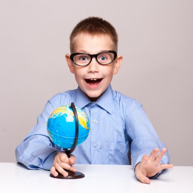 Bir küre tutan küçük bir çocuk portresi. Seyahat kavramı