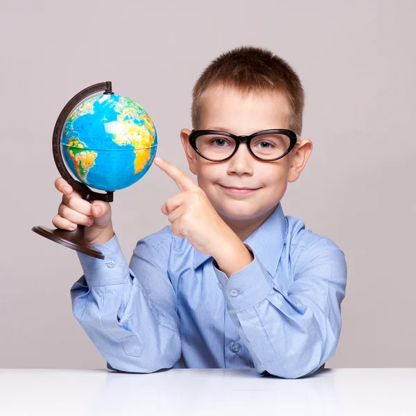 Porträt eines kleinen Jungen mit einer Weltkugel. Reisekonzept — Stockfoto