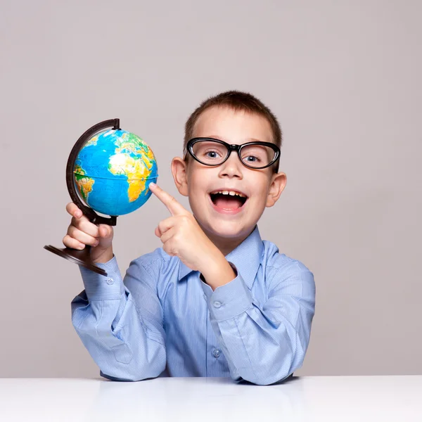 Porträt eines kleinen Jungen mit einer Weltkugel. Reisekonzept — Stockfoto