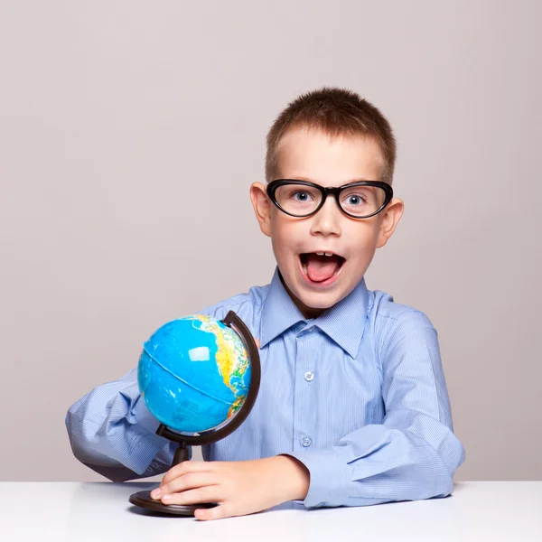 Retrato de um rapazinho a segurar um globo. Conceito de viagem — Fotografia de Stock