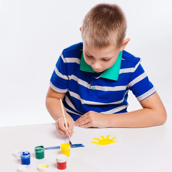 Happy cheerful child drawing with brush in album using a lot of — Stock Photo, Image