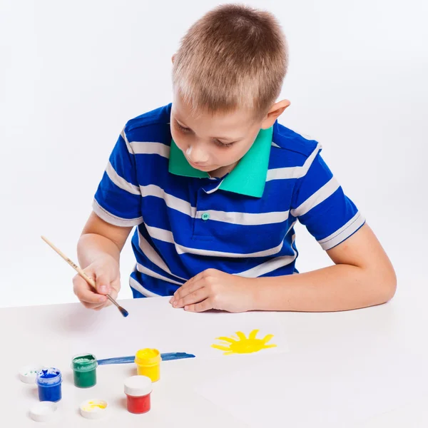 Happy cheerful child drawing with brush in album using a lot of — Stock Photo, Image