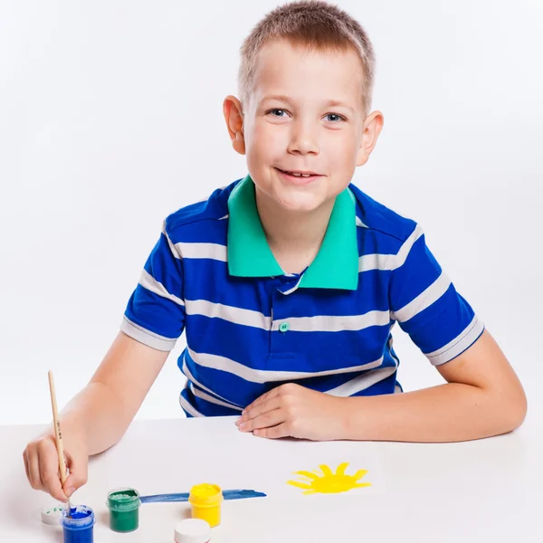 Happy cheerful child drawing with brush in album using a lot of — Stock Photo, Image