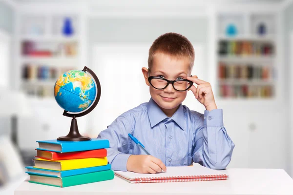 Schattig schooljongen is het schrijven van geïsoleerd op een witte achtergrond — Stockfoto