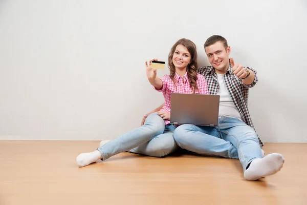 Online winkelen samen. Mooie jonge liefdevolle paar onlinetransacties zittend op de floore samen — Stockfoto