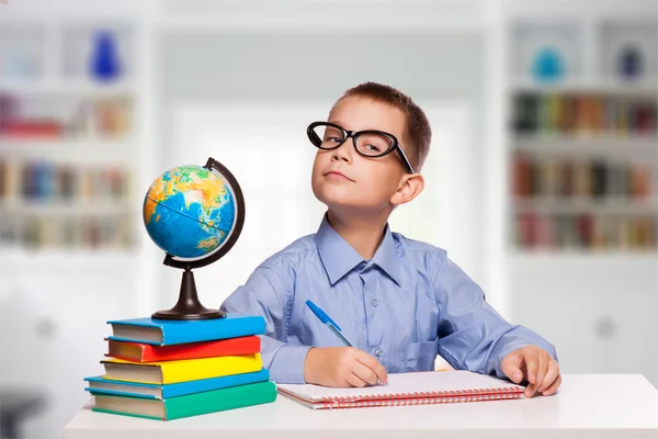 Schattig schooljongen is het schrijven van geïsoleerd op een witte achtergrond — Stockfoto