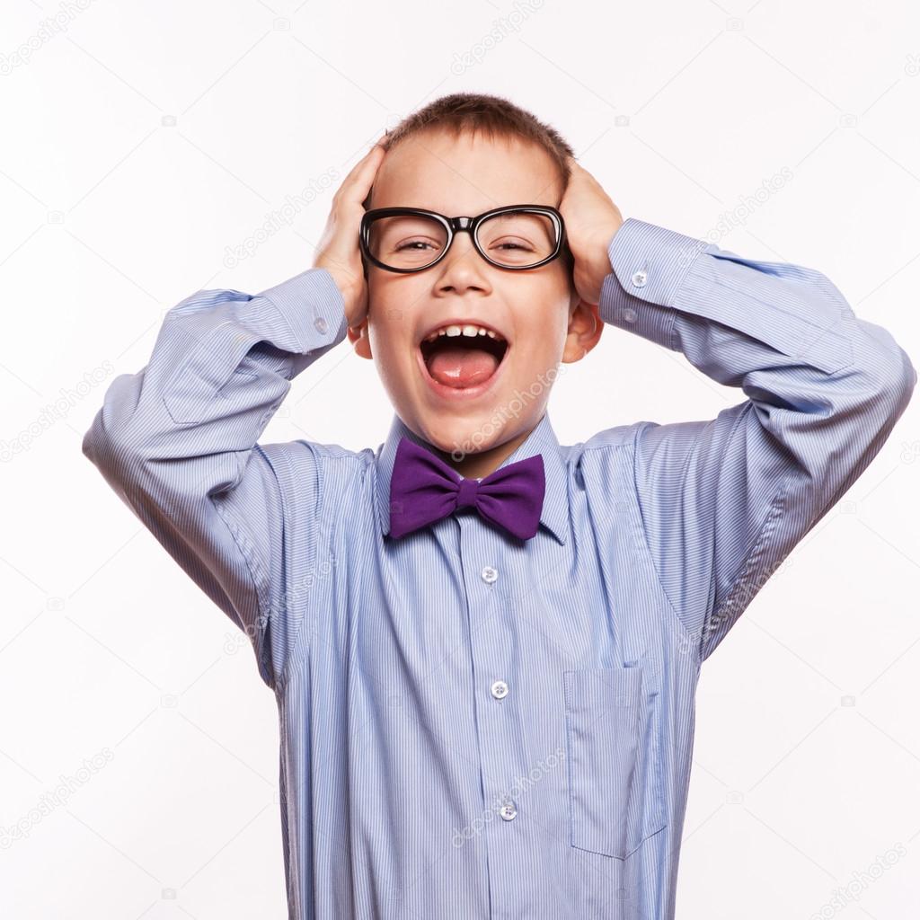 Portrait of a surprised little boy in spectacles and suit. Isolated over white background.