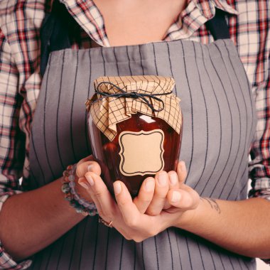 Vintage Bank peach jam in the hands of women. Close-up clipart