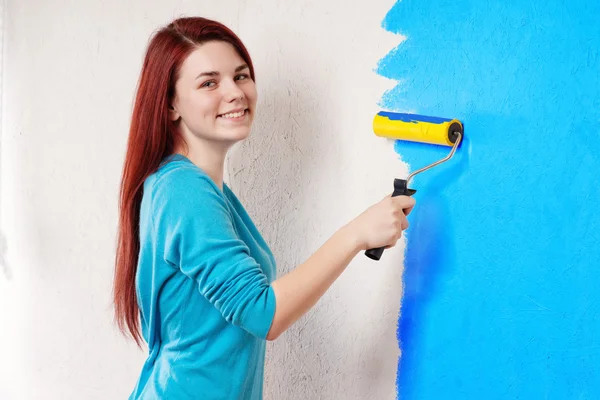 Piękna młoda kobieta robi malowanie ścian — Zdjęcie stockowe