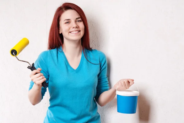 Beautiful young woman in causal clothes enjoying the result of the work she has done painting a wall — Stock Photo, Image