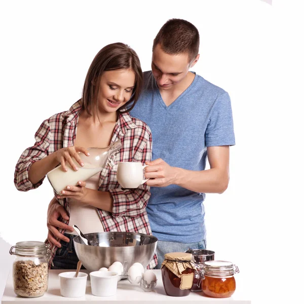 Счастливая молодая пара весело проводит время на современной деревянной кухне в помещении, готовя свежие продукты — стоковое фото