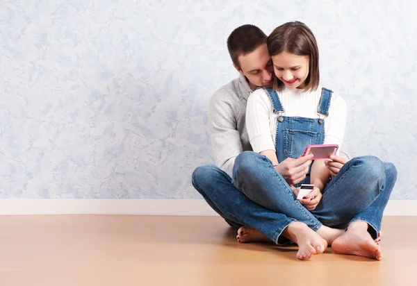 Compras en línea juntos. Hermosa pareja amorosa joven de compras en línea mientras están sentados en el suelo juntos — Foto de Stock