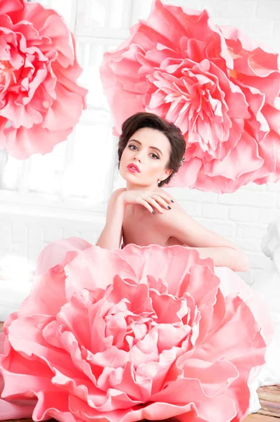 창이에 앉아 거 대 한 분홍색 꽃을 가진 긴 드레스에 아름 다운 섹시 한 여자 — 스톡 사진