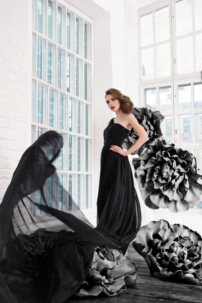 Beautiful sexy girl in a long dress with a huge black flowers. — Stock Photo, Image