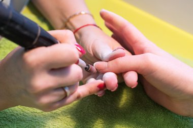 Asıl bir elektrik makine sırasında salonda manikür eller üzerinde tırnak cilası kaldırmak için kullanır. Donanım manikür. Kavram vücut bakımı