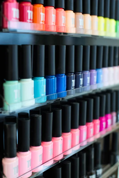 Set of different nail varnishes on shelves in cosmetic store — Stock Photo, Image