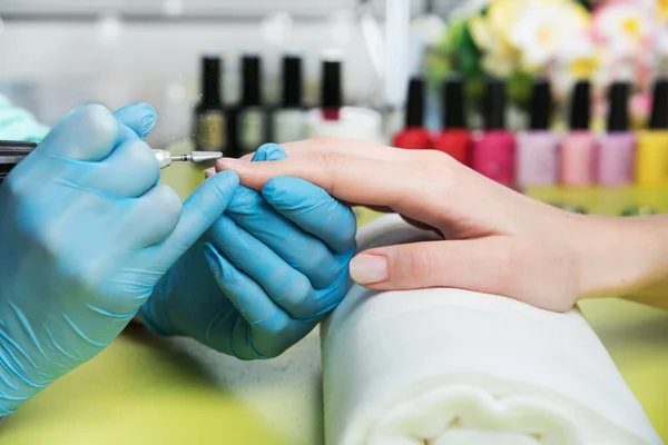 Close-up shot van een vrouw in een nagel salon een manicure door een schoonheidsspecialiste met nagelvijl ontvangen. Vrouw krijgen nagel manicure. Schoonheidsspecialiste bestand nagels aan een klant — Stockfoto