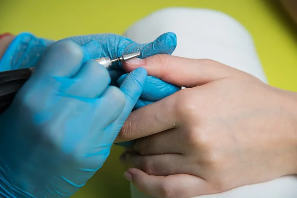 Closeup tiro de uma mulher em um salão de beleza recebendo uma manicure por um esteticista com arquivo de prego. Uma mulher a fazer manicura de unhas. Esteticista unhas de arquivo para um cliente Imagens De Bancos De Imagens Sem Royalties