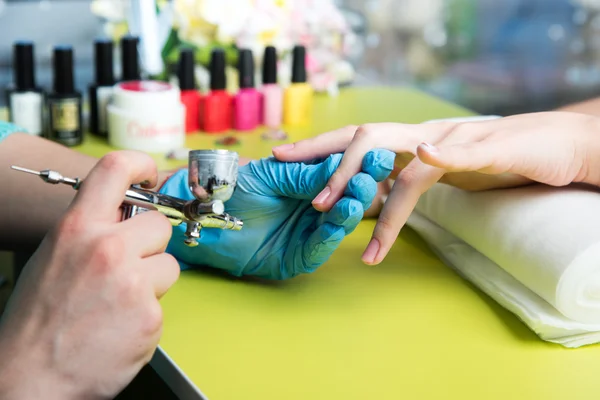 Detailní záběr ženy v nehtový salon příjem manikúru od kadeřnice s pilník. Žena stále nehty manikúra. Kosmetička soubor hřebíky k zákazníkovi Stock Snímky