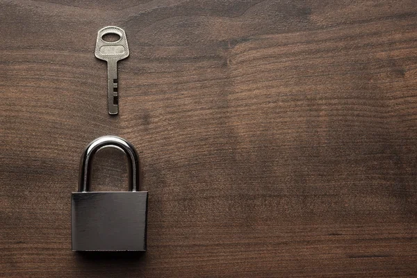 Check-lock e chave na mesa de madeira marrom — Fotografia de Stock