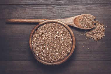 kahverengi ahşap kase masanın üzerine buğday dolu