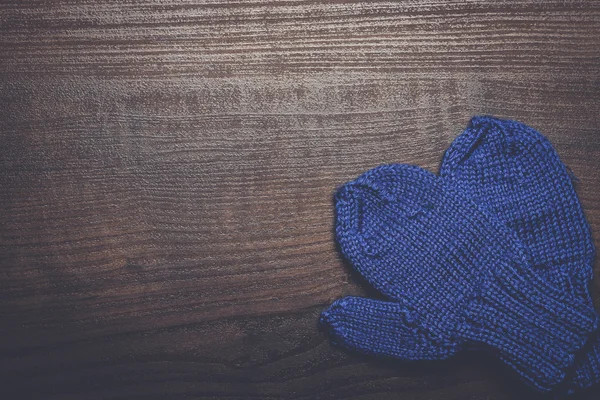 Blue mittens on brown wooden background — Stock Photo, Image
