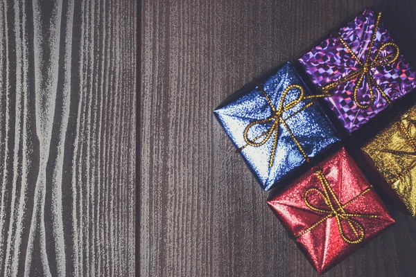 Bunte Geschenkboxen über braunem Holzhintergrund — Stockfoto