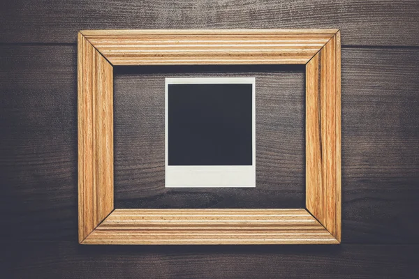 empty frame and old photo on wooden background