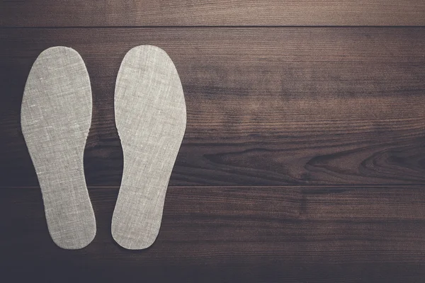 Стельки для обуви на деревянном фоне — стоковое фото