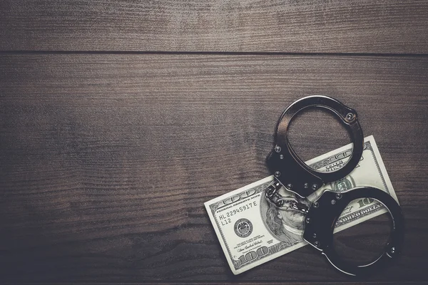 Handcuffs and one hundred dollars background — Stock Photo, Image