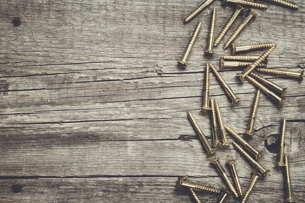 Yellow screws on the wooden table — Stock Photo, Image