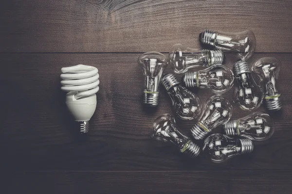 Bulb uniqueness concept on the wooden table — Stock Photo, Image