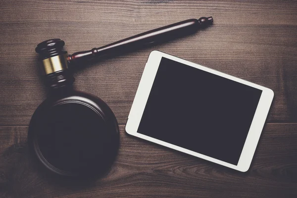 Судья молоток и планшетный компьютер на коричневом деревянном фоне судья — стоковое фото