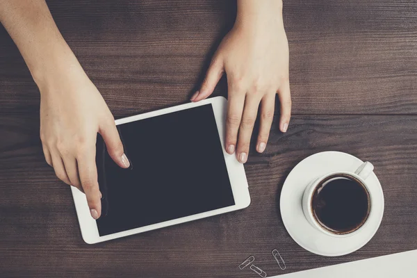 Vrouwen handen met tablet pc en koffie op tafel — Stockfoto
