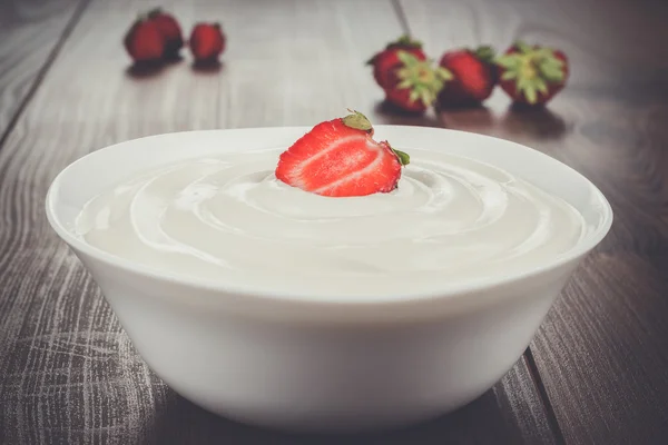 Cuenco blanco lleno de crema agria con fresa — Foto de Stock