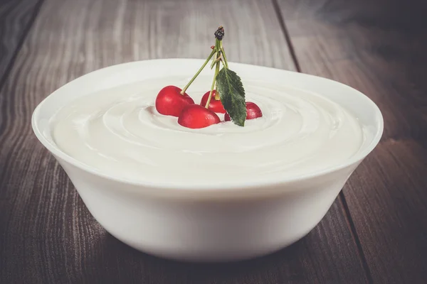 White bowl full of sour cream with some cherries — Stock Photo, Image