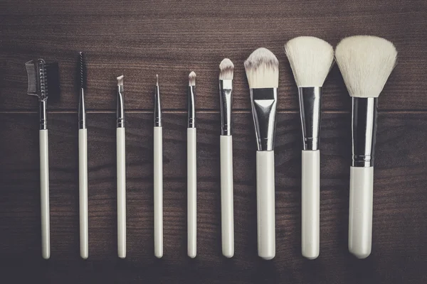 White make-up brushes on wooden table — Stock Photo, Image