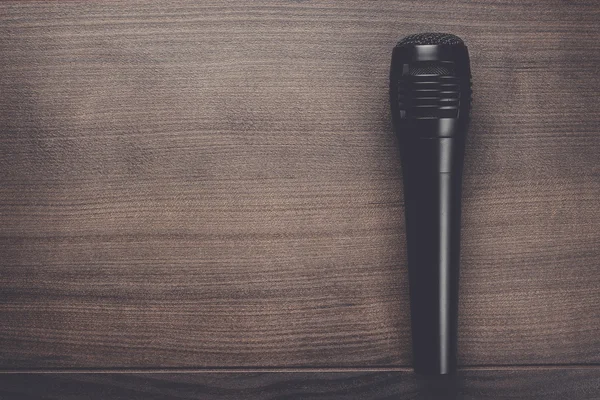Schwarzes Mikrofon auf dem Holztisch — Stockfoto
