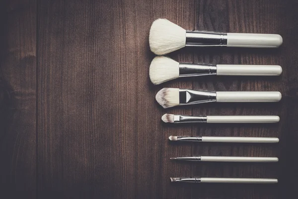 White make-up brushes on wooden table — Stock Photo, Image