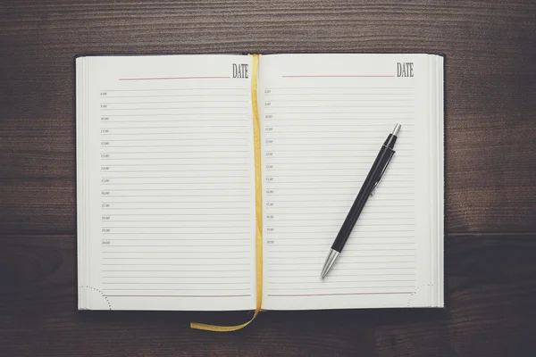 Öppnad anteckningsbok och penna på träbord — Stockfoto