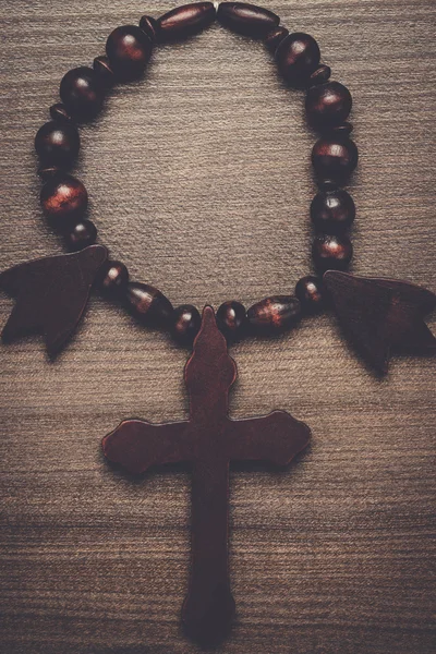 Drewniany krzyż na tle brązowy stół — Zdjęcie stockowe