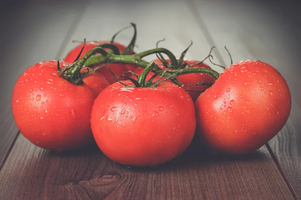 Fresh tomatoes on the brown wooden table — Stock Photo, Image