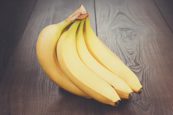 Banane fresche sul tavolo marrone — Foto Stock
