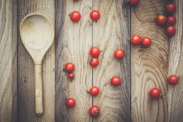 Tomates cereja e colher de madeira — Fotografia de Stock