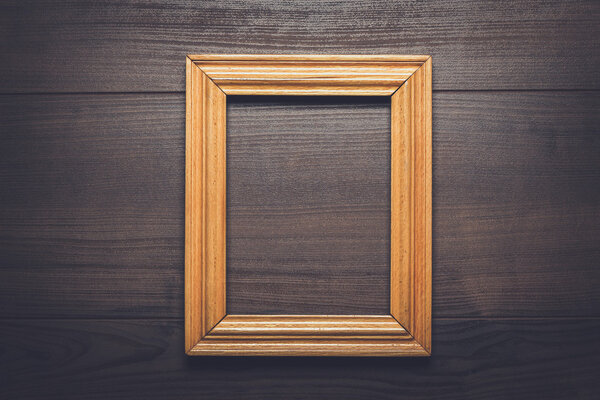 Old empty frame over wooden background