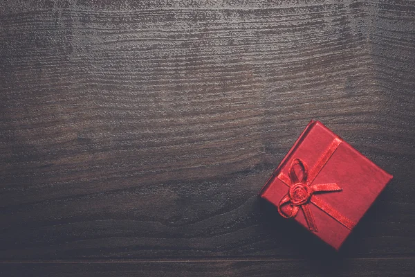 Red present box over wooden background — Stock Photo, Image