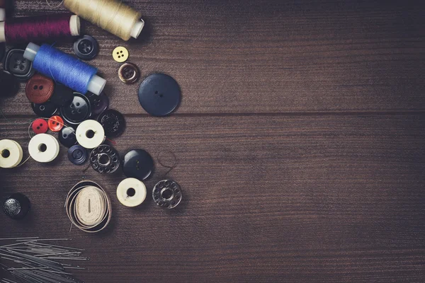 Botones de hilos y agujas en la mesa —  Fotos de Stock